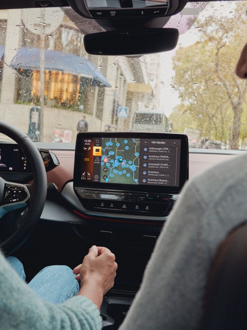 Une femme et un homme, à l'intérieur d'une Volkswagen ID. avec la carte de navigation affichée sur l'écran d'infodivertissement.