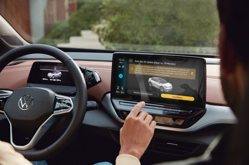 Blick auf das Navigationsgerät eines ID.5 von Volkswagen. Eine Hand tippt auf den Touchscreen und wählt Software-Updates aus.