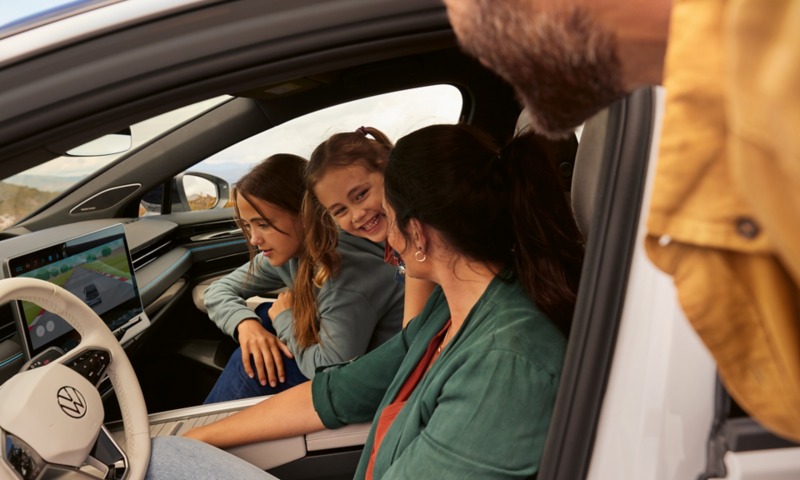 A family is sitting in the VW ID.7, one of the girls is looking at the display of the infotainment system where a game is playing.