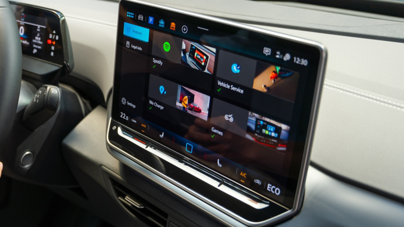 Lenkrad und Infotainment-System im VW ID.4, eine Frau sitzt auf dem Fahrersitz.