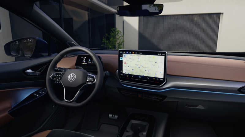  Vista del volante multifunzionale nero e dei display accesi negli interni della Volkswagen ID.4. 