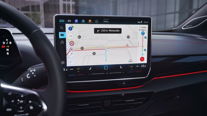 Vue détaillée de l’écran d’info-divertissement de la VW ID.4 GTX. L’écran affiche une carte de navigation, un titre musical et d’autres fonctions.