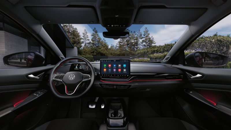 Intérieur d’une VW ID.5 GTX rouge. Vue sur le volant, l’écran, les sièges, le tableau de bord et le rétroviseur.