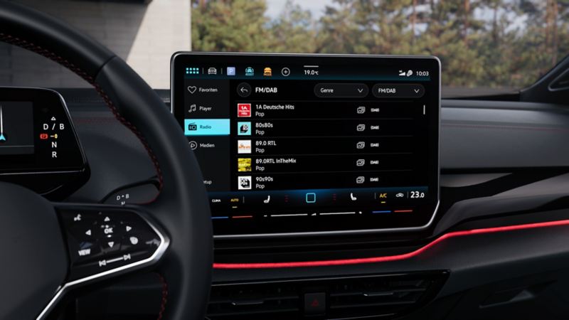 Vista dettagliata del display del sistema di infotainment nella Volkswagen ID.5 GTX. Il display mostra diverse emittenti radio.