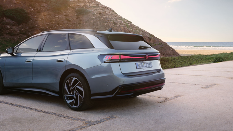 En blå ID.7 tourer parkeret ved strand