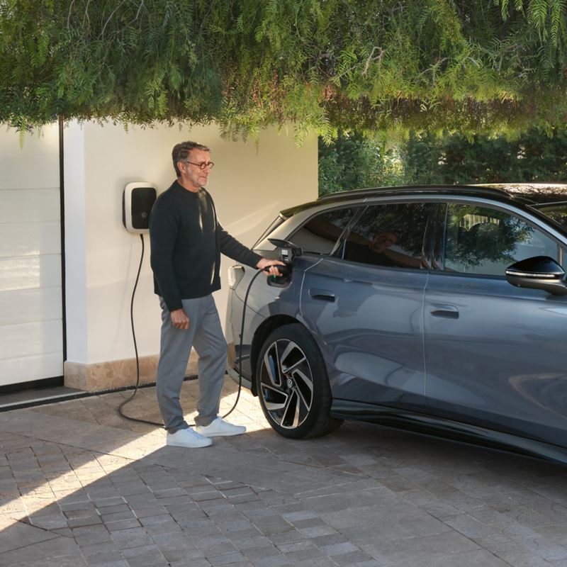 a man plugging in his electric model using a home charger