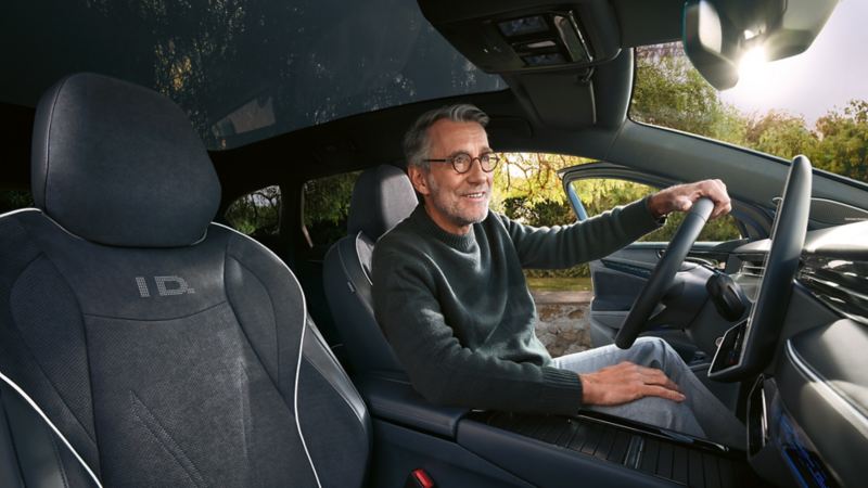 Mies istuu VW ID. 7 Tourerin kuljettajan istuimella
