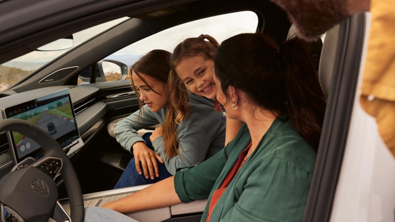 Eine Familie nutzt das Spiele-Angebot des Infotainment-Systems im Innenraum eines Volkswagen.