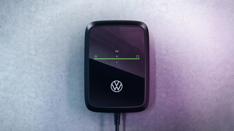 Detailansicht einer VW Wallbox ID. Charger Connect 2 mit grüner Ladeanzeige an einer Wand.