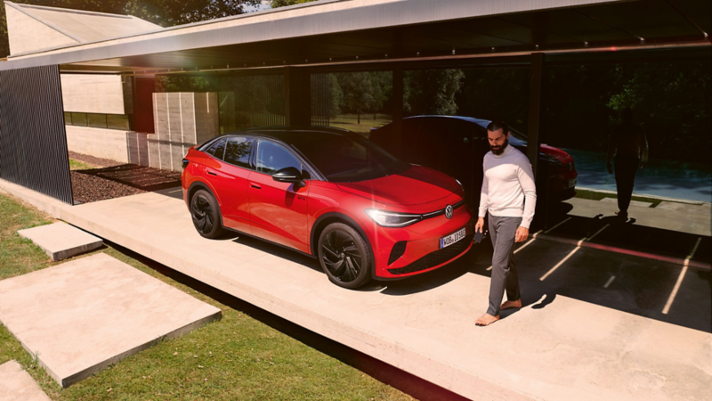 Roter VW ID.5 GTX parkend vor einem Haus. Ein Mann geht vorbei.