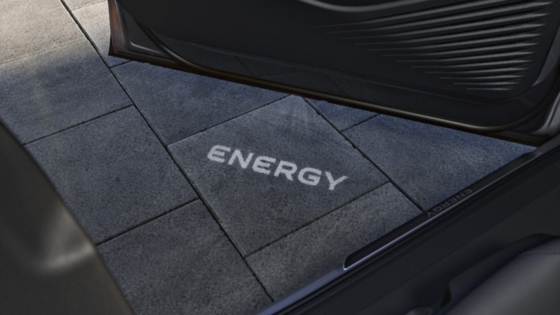 ENERGY-Schriftzug wird vor dem VW ID.4 ENERGY auf den Boden projiziert.