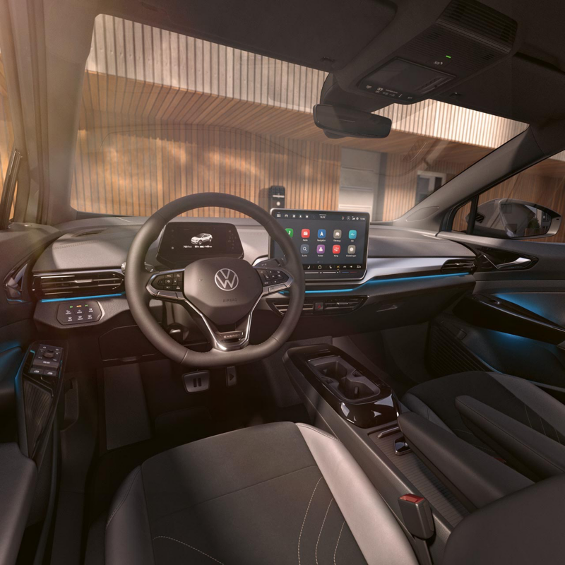 A man and a woman are sitting in the VW ID.7. The woman is operating the infotainment system.