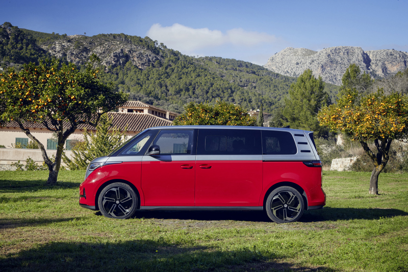 En röd VW ID.Buzz parkerad med berg i bakgrunden. ID. Buzz är Volkswagens retroinspirerade, eldrivna folkabuss som valdes till Årets elbil 2022.
