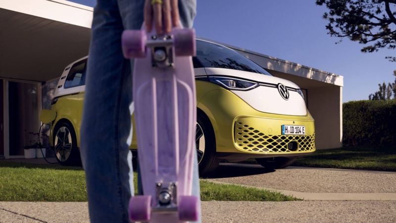 Une fillette tient sa planche à roulette devant un ID. Buzz en charge dans un garage.