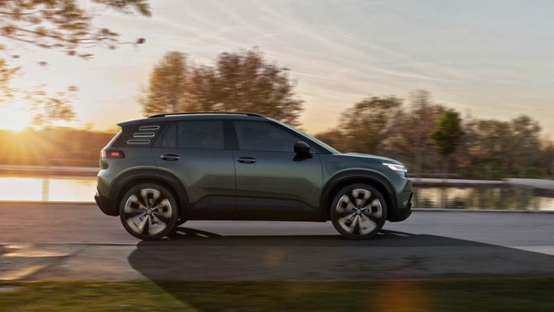 Grön VW ID. CROSS Concept sedd från sidan körandes i solnedgången.