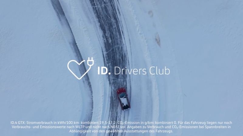 Rotes VW ID.-Modell fährt auf verschneiter Straße, ID. Drivers Club Logo im Bild.