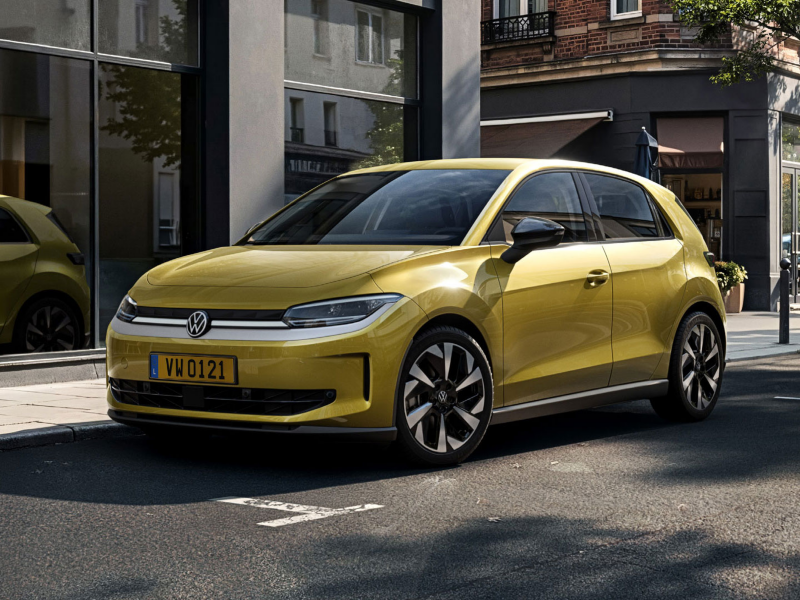 Volkswagen ID. Polo Life jaune stationnée en milieu urbain, le long d’une rue bordée de bâtiments et de vitrines.