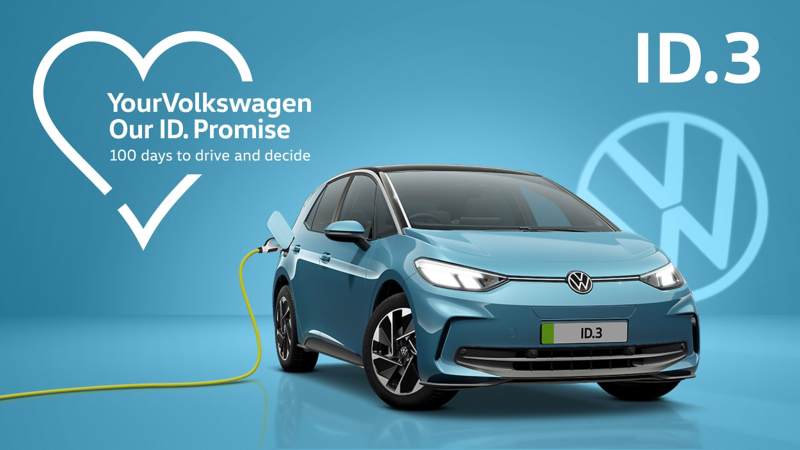 A front three-quarter view of a teal ID.3 set on a teal background with a transparent Volkswagen logo and a charging cable plugged into the charging port