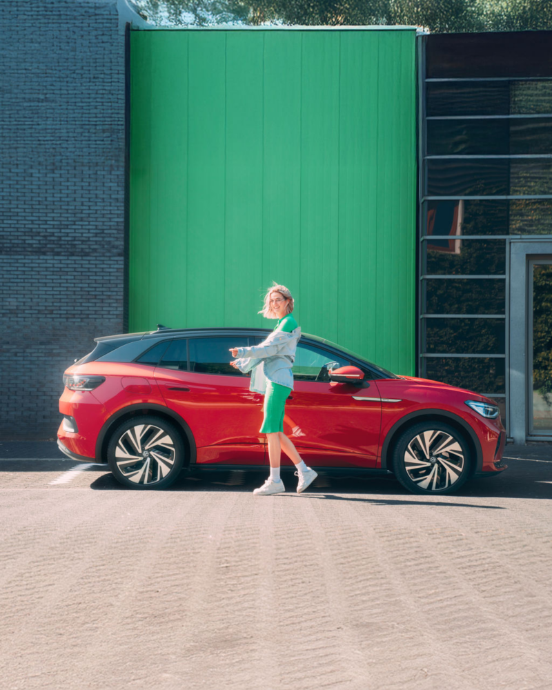 Woman standing with ID. 4 GTX parked behind her