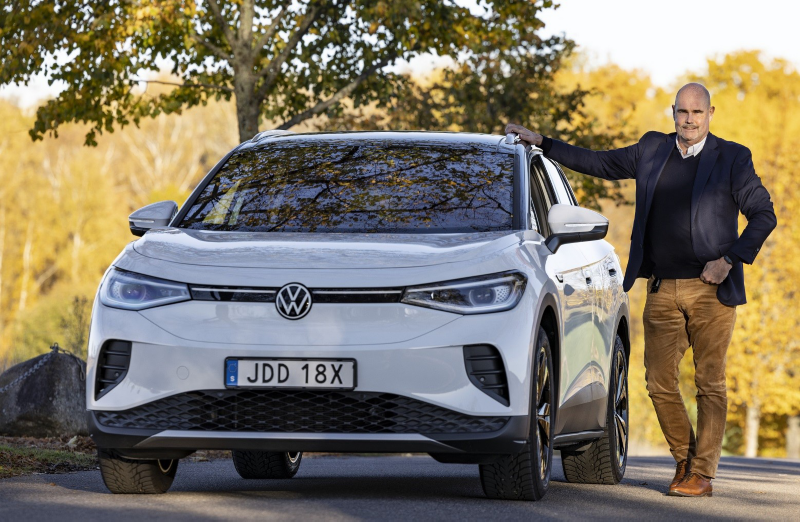 Johan Sjögren står bredvid en vit Volkswagen ID.4.