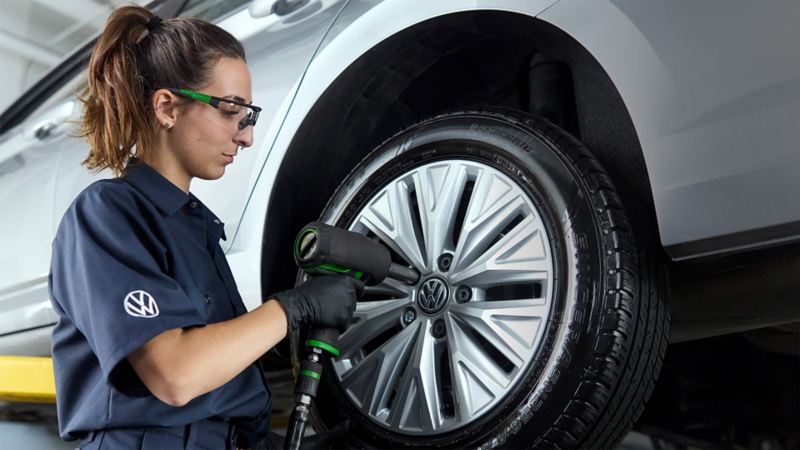 A technician in protective glasses fixing a car