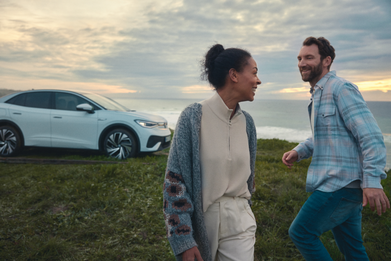Un couple devant une voiture neuve