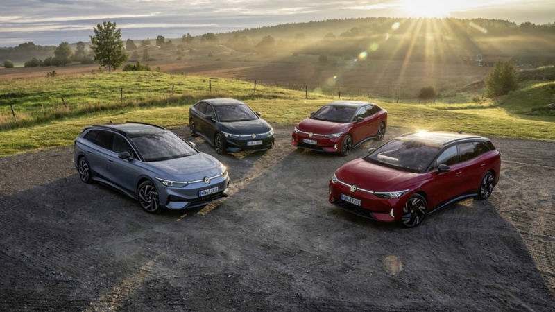 Flera Volkswagen ID.7 parkerade bredvid varandra med strålande sol i bakgrunden