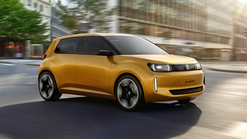 A gold coloured VW ID. EVERY1 driving though a city. 