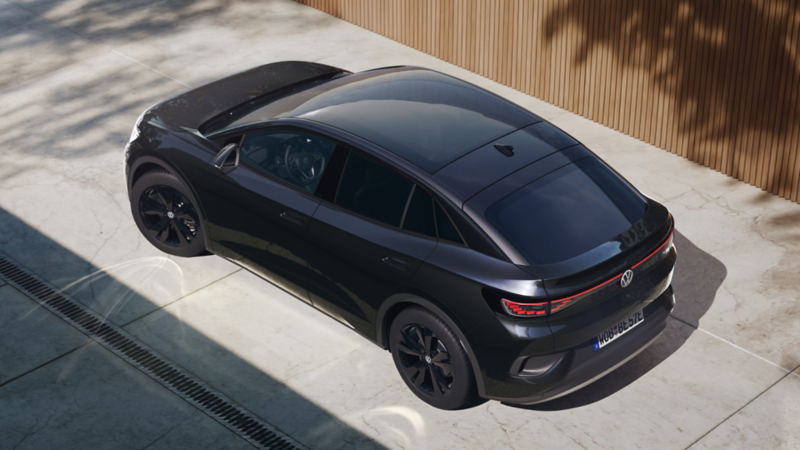 Ansicht aus der schräg rechten Vogelperspektive auf einen schwarzen VW ID.5 Black Edition vor einem modernen Haus.