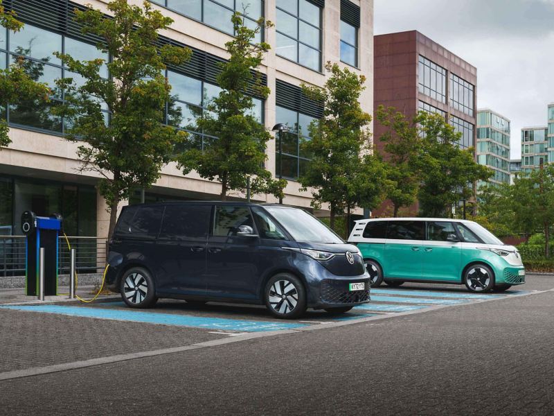 an ID. Buzz and ID. Buzz Cargo parked and charging at a public charger