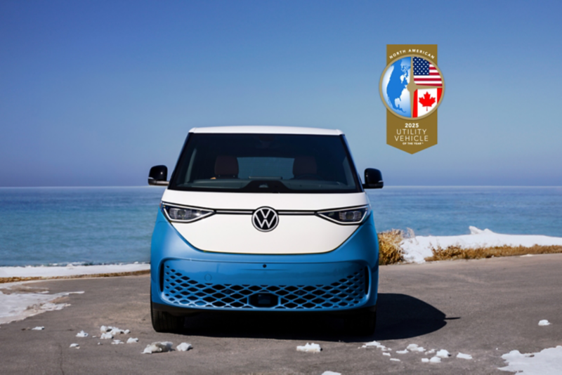 A blue and white Volkswagen ID. Buzz electric vehicle is parked in a snowy landscape.