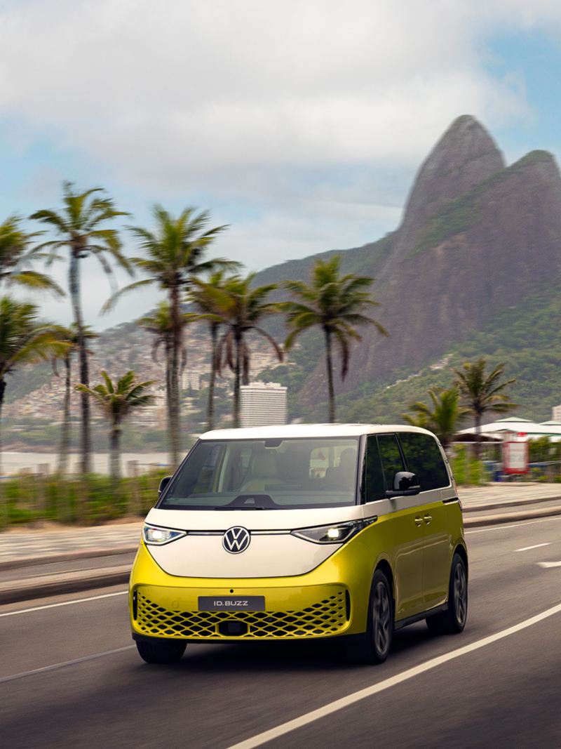 Volkswagen ID.Buzz amarelo dirigindo em uma avenida do Rio de Janeiro