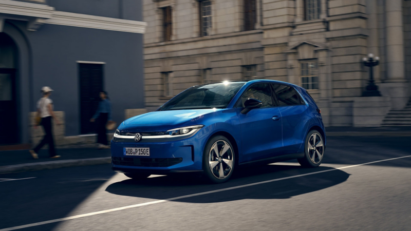 Ein blauer VW ID. Polo fährt durch eine Stadt.
