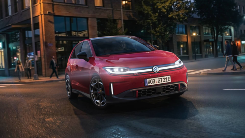 A red VW ID. Polo GTI turns into a street in an evening atmosphere.