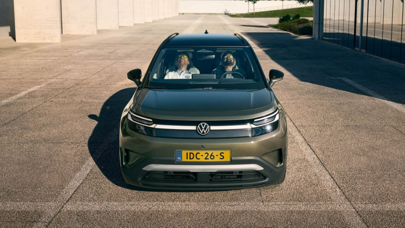 Two men are sitting in the front seats of a VW ID. Cross, leaning back with their eyes closed. 