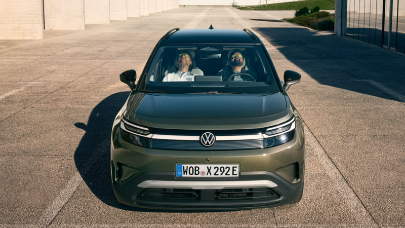 Deux hommes sont assis sur les sièges avant d’un VW ID. Cross vert, penchés en arrière, les yeux fermés.