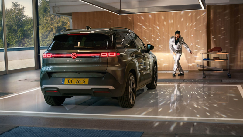 Een Volkswagen ID. Cross verlicht met zijn koplampen een dansende man in een glitterpak.