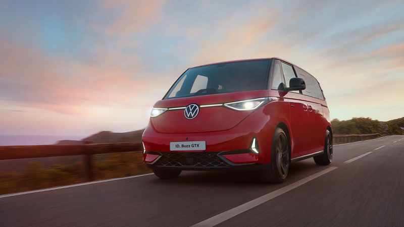A VW ID. Buzz driving along a coastline road. 