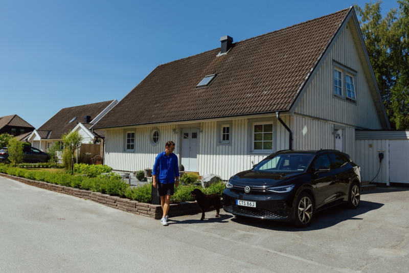 Kim Cannerheim, en labrador och svart ID. 4 står utanför huset en solig dag