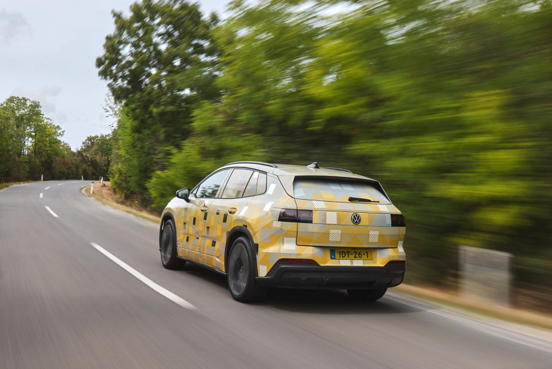 Rear view of an ID. Tiguan in camouflage livery driving on a country road.