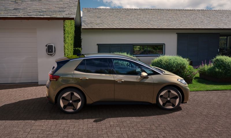 A view of a VW ID.3 parked in front of a garage.