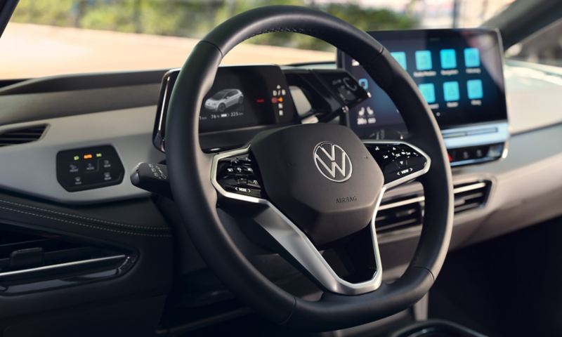 Vista degli interni dell'auto con messa a fuoco sul  volante multifunzione di VW ID.3 con il pulsante per l'assistente vocale.