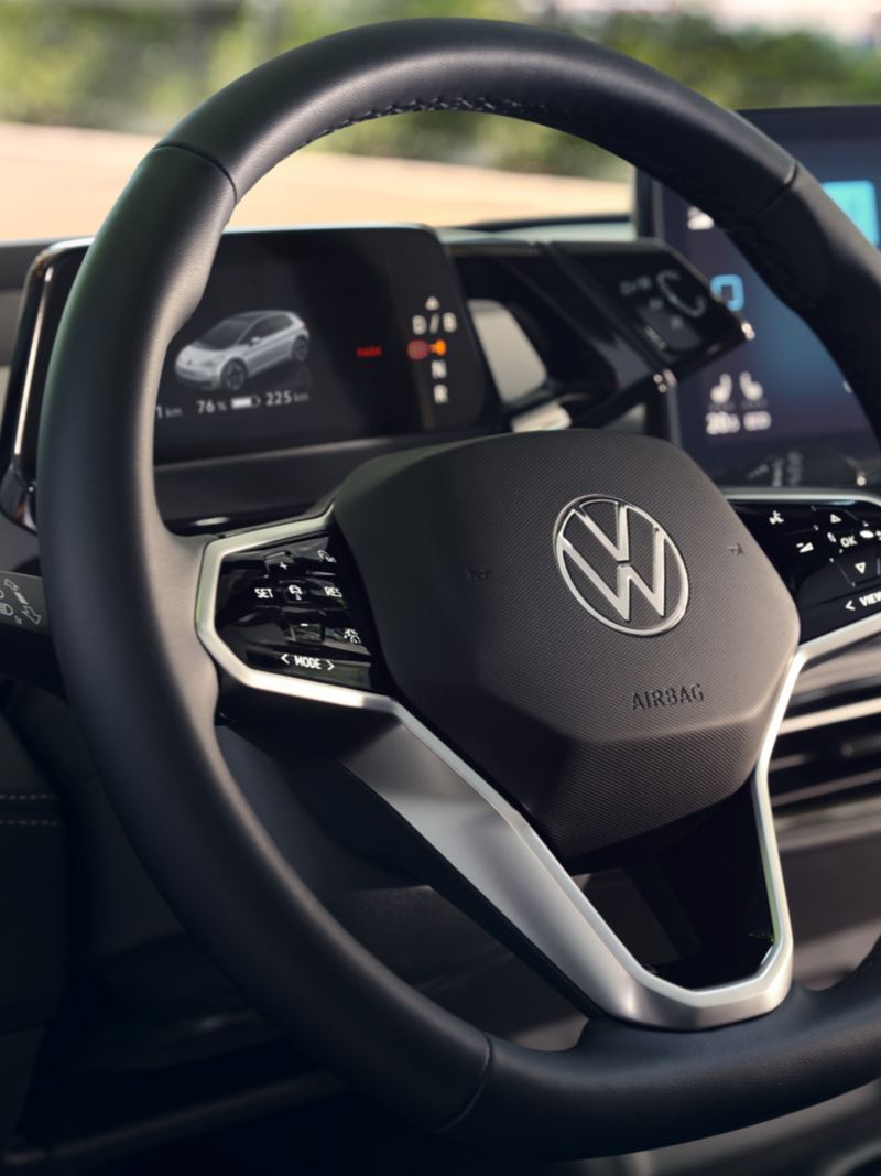 Vista degli interni dell'auto con messa a fuoco sul  volante multifunzione di VW ID.3 con il pulsante per l'assistente vocale.