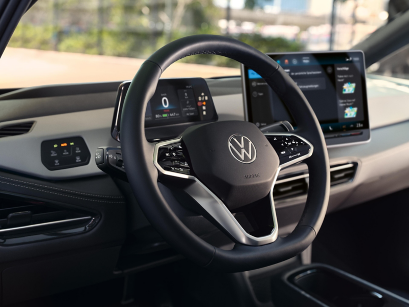 Vista degli interni dell'auto con messa a fuoco sul  volante multifunzione di VW ID.3 con il pulsante per l'assistente vocale.