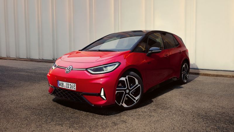 Seitliche Frontansicht eines roten ID.3 GTX vor einem grauen Gebäude