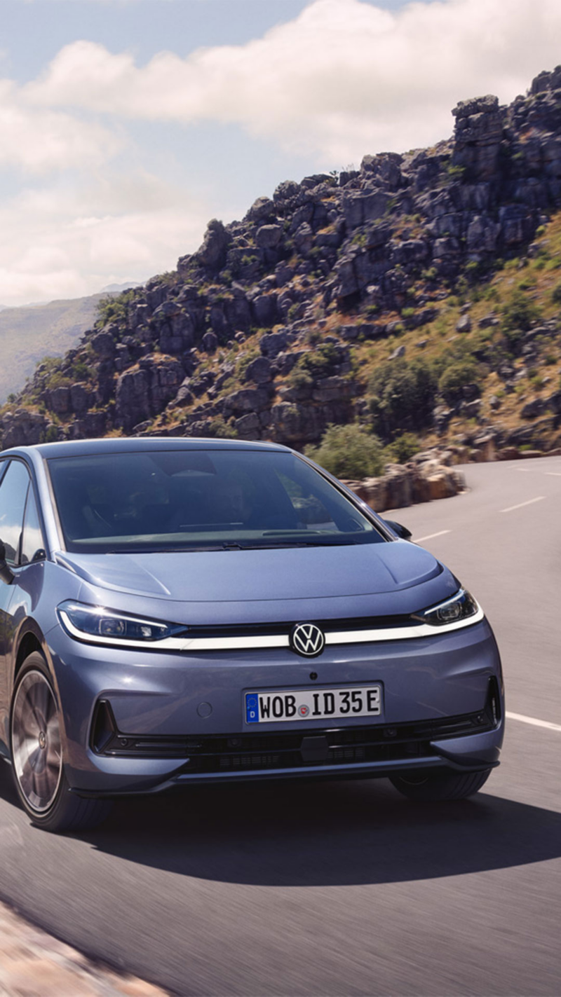 Ein blauer VW ID.3 Neo fährt auf einer kurvigen Bergstraße.