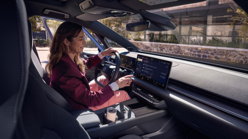 A woman selects an online function on the centre display of a VW ID.3 Neo.