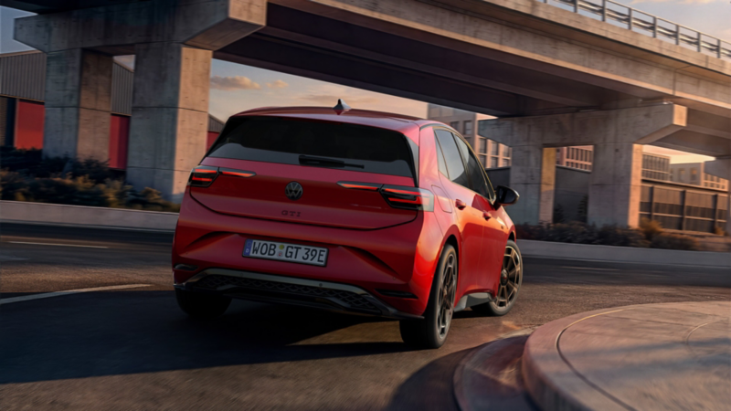 Vue arrière d'une VW ID.3 GTI rouge, avec ses feux arrière allumés.