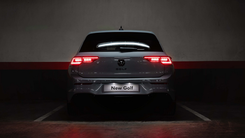Side view of a moving white VW Golf eHybrid.