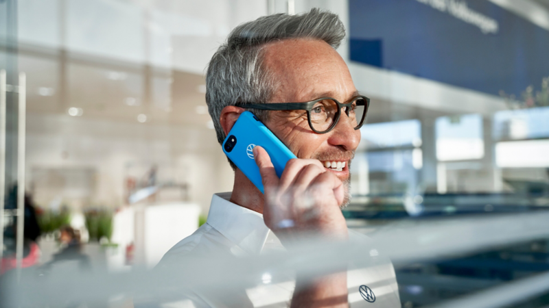 En VW service ansat taler i telefon med en kunde